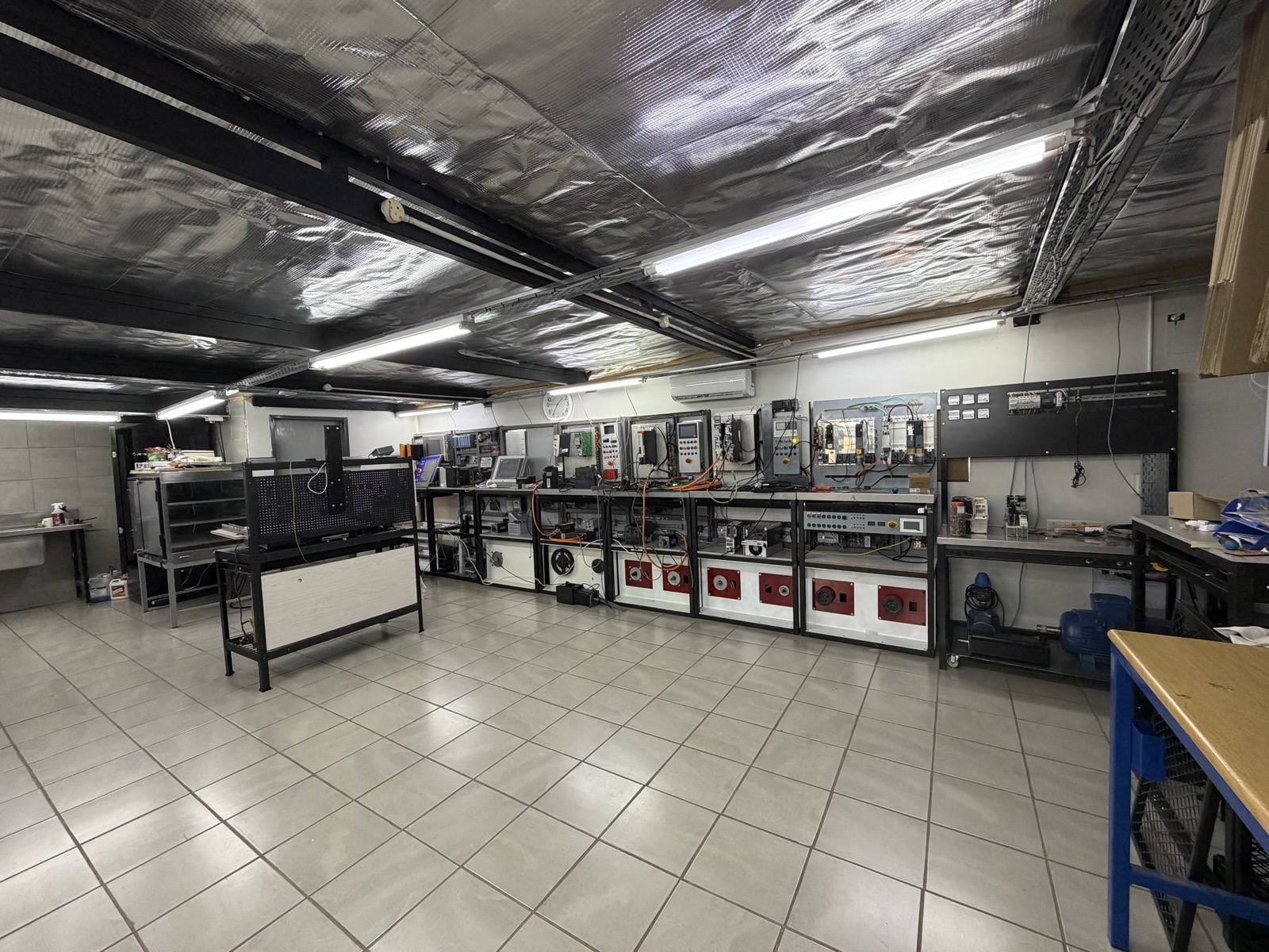 AR Sales repair workshop in Fairland, Randburg: rows of test benches with servo drives and inverters wired to red test motors
